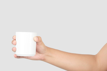 Hand holding white ceramic mug. isolated with clipping path.