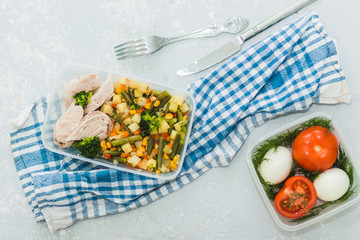 Delicious and healthy lunch. Chicken meat with boiled vegetables in container on grey background, close up. Healthy food