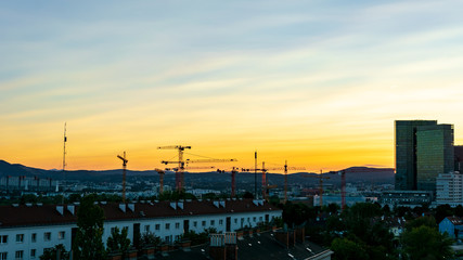 Sunset over Viennas Wienerberg area with office buildings and a construction site in the foreground