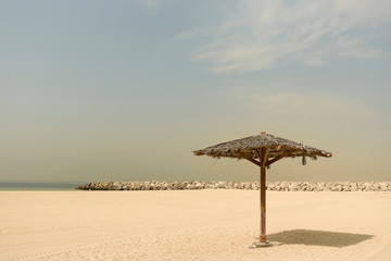 Thatched Parasol on an empty Gold Beach. Vintage. Al Mamzar, Dubai, Emirates, Jul.2018