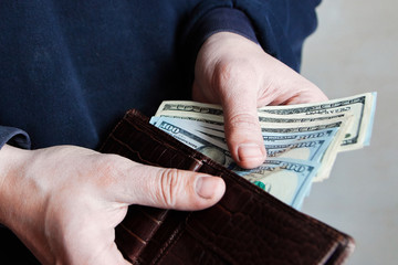 Hands taking out money from wallet Concept of savings, salary, payment and funds