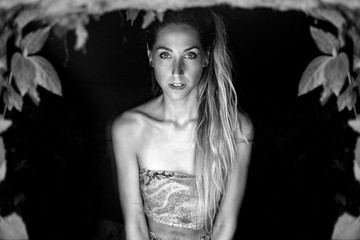 black and white photo of beautiful woman with long hair posing on dark background