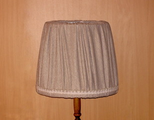 Lamp floor old retro and its upper textile part, on the background wall imitating wood