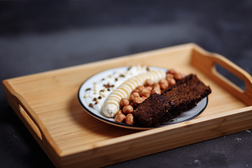 Healthy breakfast bowl on the kitchen table, selective focus. Rye bread, banana, hazelnut, chocolate muesli and yogurt