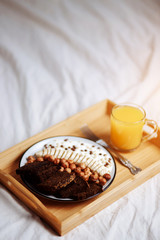 Healthy breakfast in the bedroom in bed Fruits, nuts, pieces of bread and banana in a plate