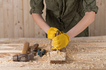 Close up of a carpenter planing a plank of wood with a hand plane