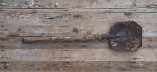 old rusty shovel on a wooden background