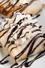 european pancakes, sweet crepe with topping on white long plate