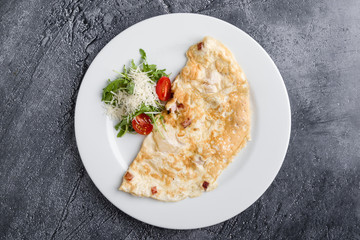 filled omelette with cheese and tomato on white plate