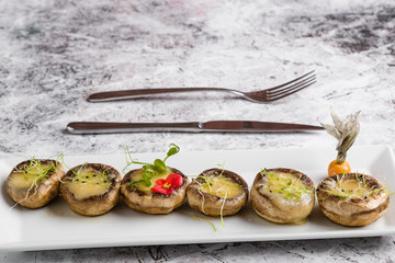 grilled mushroom stuffed with cheese on white plate