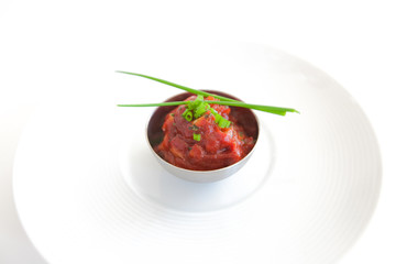 Italian tomato sauce with chives, onion and garlic on white plate and table