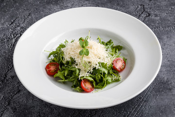 fresh tasty healthy rucola salad in white plate
