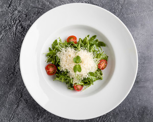 fresh tasty healthy rucola salad in white plate