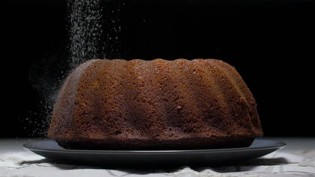 sprinkling with powdered sugar on a marble cake