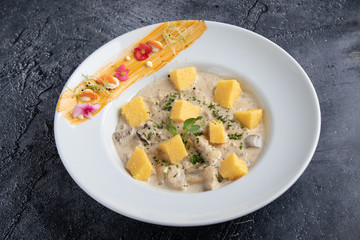 chicken with mushrooms sauce and polenta cubes in white table