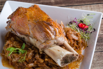 bavarian pork knuckle with cabbage on white plate