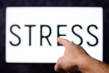 Man pointing to a TV set with inscription STRESS in order to show main reason of problems