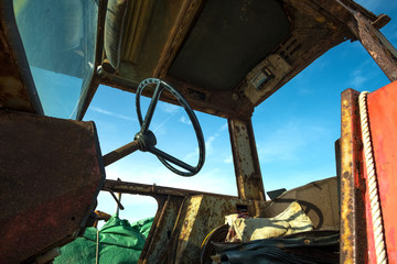 Rivers cab and steering wheel on an old rusting tractor