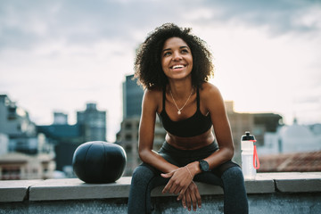 Smiling woman athlete taking a break during workout