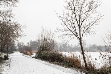 park and frozen lake covered in snow
