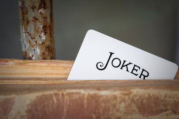 Playing card The joker looks out of an old, vintage book.