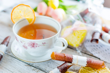 cup of tea with lemon and sweets