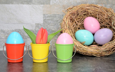 easter eggs in colored buckets with bird nest