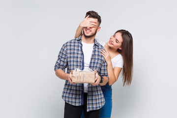 Couple of two happy people, girl give gift for her boyfriend. Happy smilling.