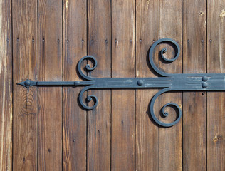 wooden gate with wrought iron elements close up.
