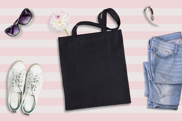 Black tote bag mockup, flat lay on summer style background 