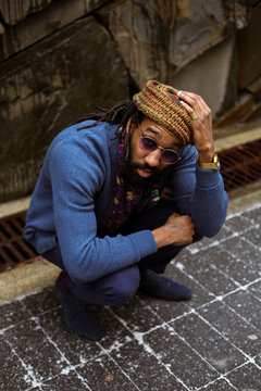 Portrait of man wearing sunglasses crouching outdoors