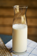 Bottle of milk on wooden background, close-up. Healthy breakfast concept