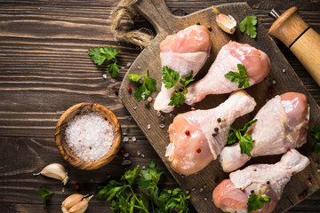 Chicken legs or drumctick on cutting board.