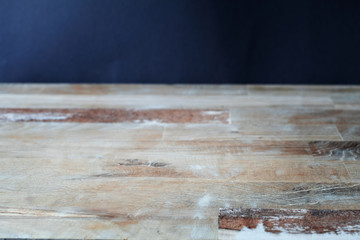 Old wooden table in front of black chalkboard wall for your text. View with copy space