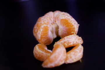 ripe tangerine slices on a dark background in isolation