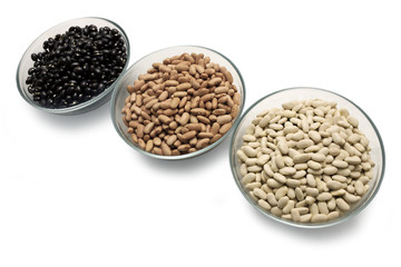 Beans are black, brown and white in glass bowls