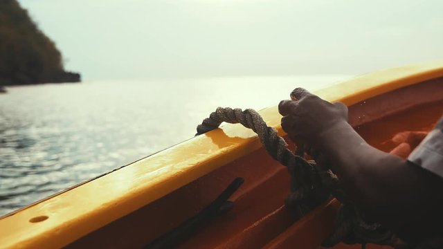 Fisherman tying a knot on his boat