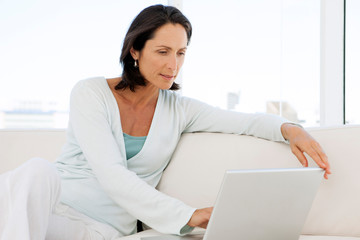 beautiful middle aged woman using computer at home