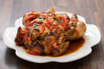 roasted chicken with herbs and vegetables on white dish