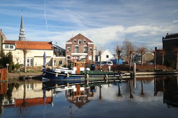 old museum harbor of Gouda with historic ships at mallegatsluis sluice to the Hollandsche IJssel in the Netherlands