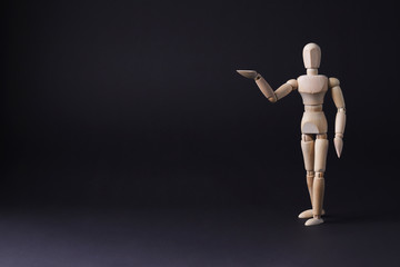 A wooden mannequin shows with his hand. The concept of pointing at someone with your finger. The mannequin will stretch out his hand. Wooden man concept. Wooden mannequin