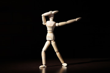 A wooden mannequin shows with his hand. The concept of pointing at someone with your finger. The mannequin will stretch out his hand. Wooden man concept. Wooden mannequin