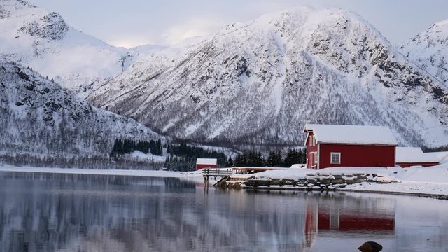 Fiskefjorden, Lofoten Islands, Norway - February 3 2019: house and reflected mountain on Fiskefjorden (fjord) in winter season, Lofoten archipelago