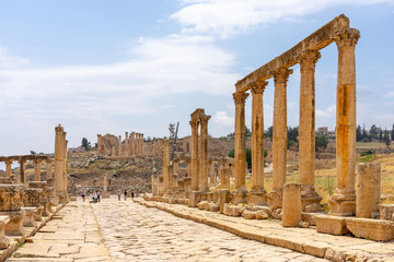 Fototapeta premium Cardo Maximus, main colonnaded street of the Roman city of Jerash, Jordan. Zeuss temple on background