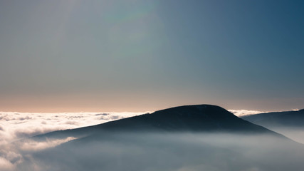 The peaks of the snowy mountains above the clouds