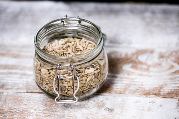 Shelled sunflower seeds in a jar on a wooden background. Healthy vegan food