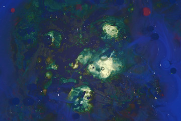 Abstract background of a drop of paint on the water surface. blue green colors