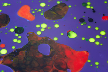 Abstract background of a drop of paint on the water surface. blue red yellow color drops