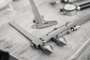 Metal measuring instruments on a wooden table. Product quality control.