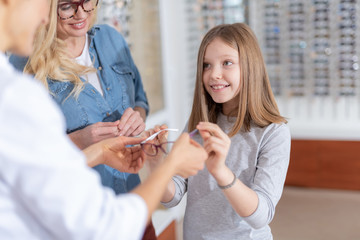 Fototapeta premium Positive nice girl trying up glasses for a better eyesight